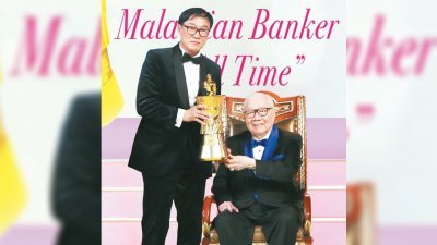 郑鸿标（右）从KK佐汉手中接过“史上最杰出的大马银行家”奖杯。