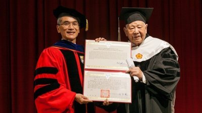 享誉文坛的台湾诗人洛夫（右）周一病逝。这是他在去年12月22日，获颁中兴大学名誉文学博士学位。