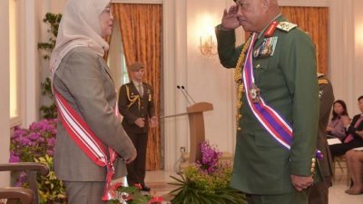 新加坡总统哈莉玛（左）把象征新加坡最高军事荣誉的殊功（军事）勋章颁给马来西亚陆军总长莫哈末阿凡迪上将。
