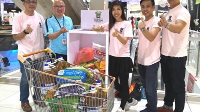 吴祝光（左起）、刘德清及许沛慈等志工响应食物银行快闪活动，成功将位于五福城广场的食物收集箱填满。