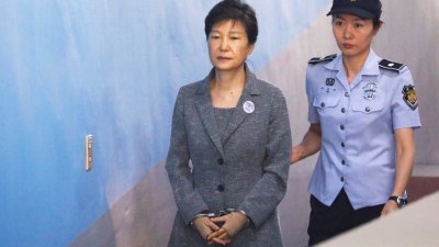 韩国前总统朴槿惠（左）在闺蜜干政案中，被控18项罪名。这是朴槿惠在去年8月25日，被带到首尔法庭受审。
