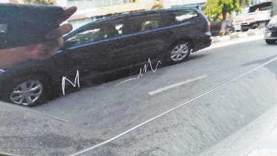 马华支会主席新车被刮花，写上M字；可见新车漆面十分光亮，还可反射出街景。