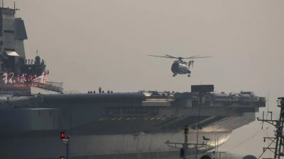 停泊在大连造船厂的首艘中国国产航母，周六清晨首次起降直升机。