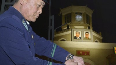 朝鲜平壤车站建筑上的时钟，周六凌晨调快半小时，与韩国同步进入12时。一名穿著制服的人士在车站前广场，也将手表从11时30分调至12时。