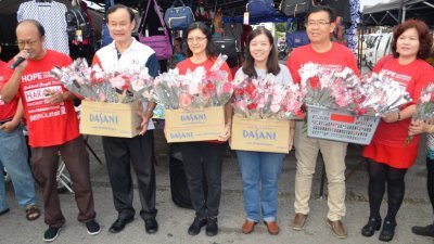 倪可汉夫妇（左2起）和黄渼及团队在爱大华巴刹谢票及派发康乃馨给妇女，以庆祝母亲节。