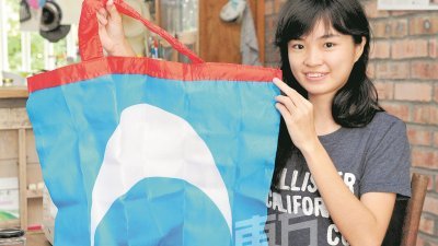 李慧君将公正党旗帜制作成可折叠的环保袋。