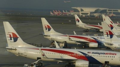马来西亚航空（简称马航）的官网上，已将台湾列为中国省份。这是2014年7月25日，地勤工作人员们在吉隆坡国际机场的马航飞机之间值勤。