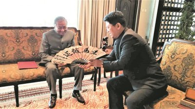 中国驻马大使白天（右）拜见马哈迪时，将一把写著“老马识途”的扇子赠送给马哈迪。