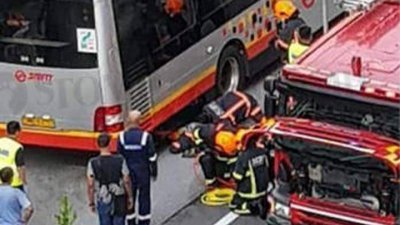 民防人员尝试救出受困巴士轮下的男童。