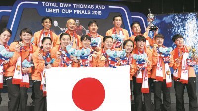日本女队在打破长达37年尤伯杯的冠军荒后，拿著国旗与冠军奖杯来张全家福合照。