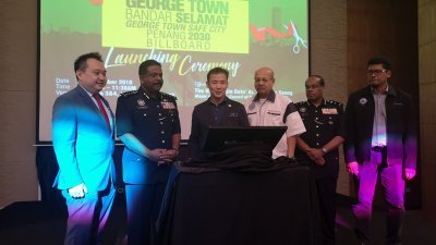 尤端祥（左3）与泰威甘（左2起）和马来西亚防范罪案基金槟城分会主席拿督斯里赛嘉化，偕同嘉宾们为“打造乔治市安全城市”进行推介礼。