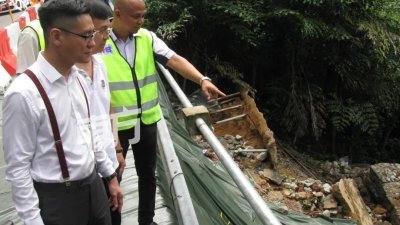 再里尔（左起）和魏祥敬等人巡视发生土崩的浮罗山背路路段。（摄影：黄俊南）