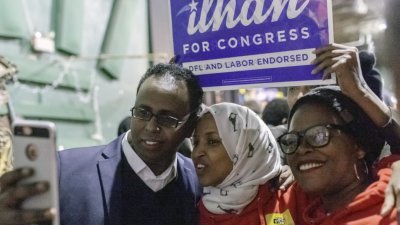 明尼苏达州民主党众议员候选人奥马尔（中）周一拉票时与支持者自拍。索马里难民出生的奥马尔，预料将成为其中一位首度进入美国国会的穆斯林女性。