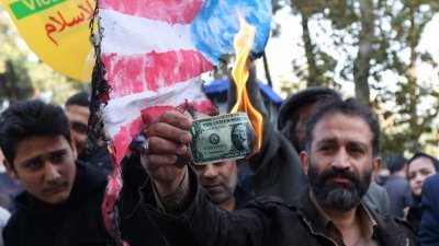 伊朗民众在德黑兰的美国大使馆前示威，抗议美国制裁伊朗。有示威者焚烧美元纸钞泄愤。