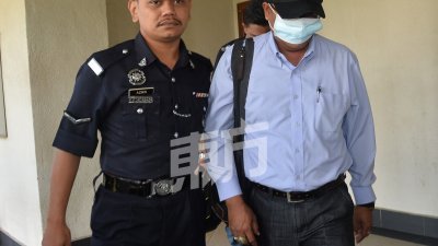 商业罪调查组警官阿布峇卡（右）被控上法庭时，用帽子及面罩遮住自己，不让样貌曝光。