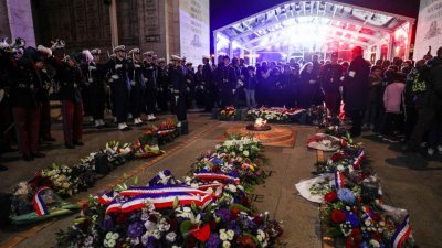 出席悼念活动的各界人士，在法国巴黎凯旋门下围绕无名战士墓，悼念一战中为和平做出贡献的亚洲人。
