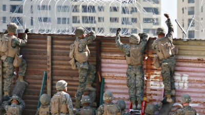 美国士兵在加州圣伊西德罗的美墨边境围墙，安装铁丝网严防移民入境。