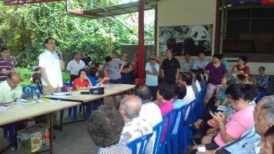 周忠信（左站者）出席君隆南峇村村民对话会，承诺将把村民诉求带上官方讨 论，尽快寻求和平方案解决村内基建问题。