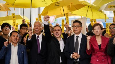 香港占领中环运动的发起人朱耀明（前排左2起）、戴耀廷和陈健民，周一早上8时许抵达法院时，有超过100名支持者到场声援，撑起黄伞高呼“公民抗命”等口号。