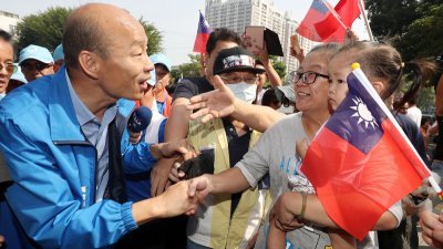 国民党高雄市长候选人韩国瑜（左）周三在高雄市进行车队扫街拜票，不少支持者争相与他握手。