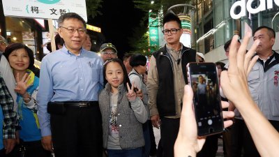 台北市长柯文哲（左2）周二晚到西门町商圈扫街受热烈欢迎，大批民众排成长长人龙，与柯文哲合影。