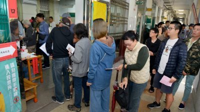 台湾九合一地方选举投票于周六登场，台北市的一所小学投票站，一早就出现排队人潮。选民耐心地排队等候领票，现场也有警卫人员在维持秩序。