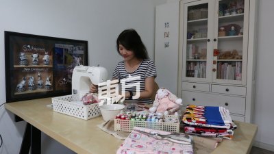 杨秋薇在工作室完成 每项订单，除了手作娃 娃，也有缝制其他作品杯垫及宝宝单等。