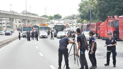 警方科学鉴证组警察在封锁的大路上，进行精密测验，以调查骚乱事件暴徒的来往路线。