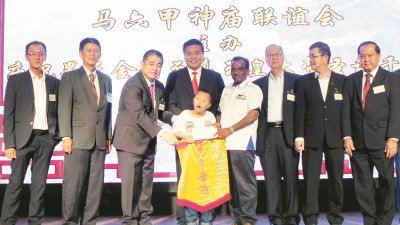 郑国球（左4）见证神庙联谊会理事移交捐款予武吉峇鲁残障儿童中心代表，左3为孙殿赐。
