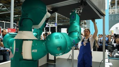 汉诺威IT展今年首度从3月改到6月。这是卡尔斯鲁厄理工学院研制的工业协作机器人，在展览中帮助工人完成天花板的拆卸工作。