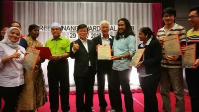 “槟州绿色新闻奖”获奖媒体在接领奖状后，与罗查理（左3起）、曹观友及彭文宝合 影，右为本报记者黄俊南。