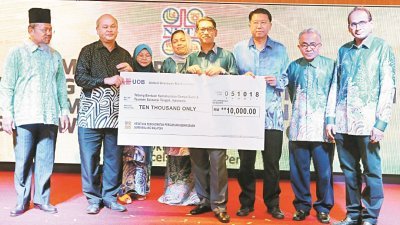 曾泰春（左2）代表大马教师职工会移交一万令吉捐助印尼地震的捐款，并由阿末费沙（左3）见证。