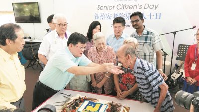 在银禧老人院主席苏珣贵（左起）陪同下，曹观友亲自喂老人院内最老的老人吃蛋糕。