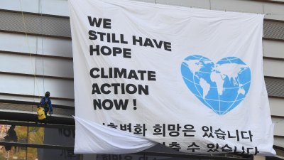 IPCC在韩国仁川市的松岛国际会展中心召开记者会，公布报告当天，环保组织“绿色和平”在会展中心外，挂上写著“我们还有希望，现在就行动”的布条。