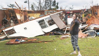 飓风“迈克尔”周三在美国佛罗里达州登陆，席卷了美国东南沿岸，带来巨大破坏。巴拿马城的一名住户，一脸无奈地站在遭飓风吹毁的屋子前。