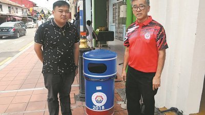 陈劲源（右） 呼吁民众把垃圾丢入新垃圾桶内，维持鸡场街的整洁，左为黄伟贤。