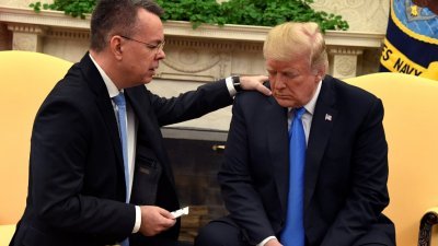 美国总统特朗普（右）在白宫接见刚获土耳其释放，飞回美国的布伦森，并接受对方祈祷。