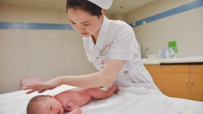 中国人民生育意愿持续下降，“全面二孩”政策实施两年来，年出生人口未超过1800万。这是在福建省一家妇幼保健医院内，护士正在为新生儿抚触。