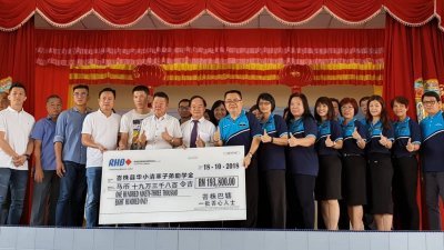 沈潺泽（左8起）移交模拟支票予峇县36所华小校长，由苏立顺代表接领，陈大锦见证。