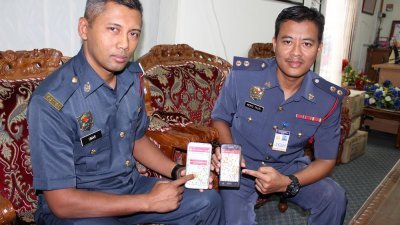 巫玛（左）及莫哈末法巫兹 ，展示峇株巴辖消拯局推出全 国首个“消防栓”应用程式（Batu Pahat Hydrant）。