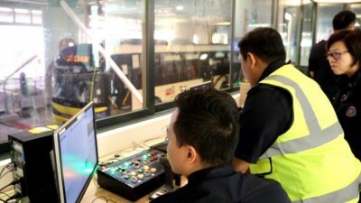 新加坡大士关卡人员利用射线照相扫描系统在一分钟内彻 查巴士，确保非法移民与非法物品无法顺利通关。