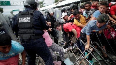 移民试图跨过危地马拉的哨所，以便进入墨西哥。移民互相推挤，警方用以阻止移民前行的栏杆被推倒且变形。