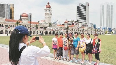 独立广场草场是游客其中一个拍照打卡的热门景点，图为一群中国游客在独立广场观光时留影。 