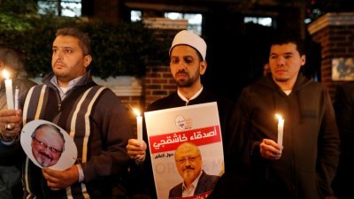 土耳其民众手持蜡烛和印有异见记者哈苏吉肖像的海报，聚集在他遇害的沙地驻伊斯坦布尔领事馆外，要求当局彻查真相。