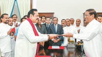 斯里兰卡前总统拉贾帕克萨（前左），在总统西里塞纳见证下，宣誓就任总理。