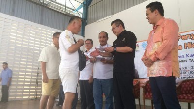 沙拉胡丁阿育（右2）颁发渔民生活补助金给柔南渔民协会会员。莫哈末法力（右起）及嘉玛鲁丁奥曼陪同。