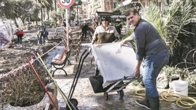 在意大利热那亚附近的拉巴洛，人们在水退后清理一片狼藉的街道。