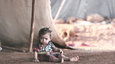 叙利亚反对派武装最后占据的伊德利卜省近日局势紧张，恐将再度酿成人道主义灾难。伊省东南部一个村庄内，一名嗷嗷待哺的幼童正坐在临时帐篷外。