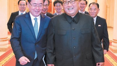 韩国国家安保室长郑义溶（左）在平壤会议地点，与朝鲜最高领导人金正恩开心交谈，后方是韩国特使团和朝鲜官员。