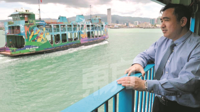 生平第一次乘搭槟城渡轮的陆兆福，感受吹海风的感觉。（摄影：蔡开国）